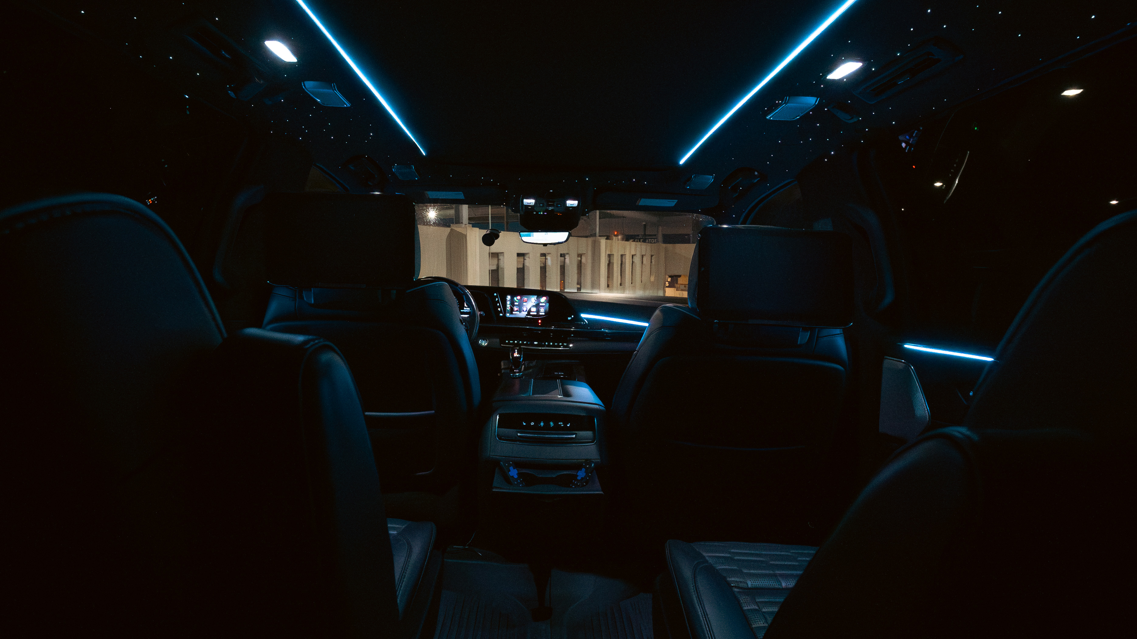 Rear cabin with fiber optic star ceiling, blue ambient lighting, and rear entertainment screens